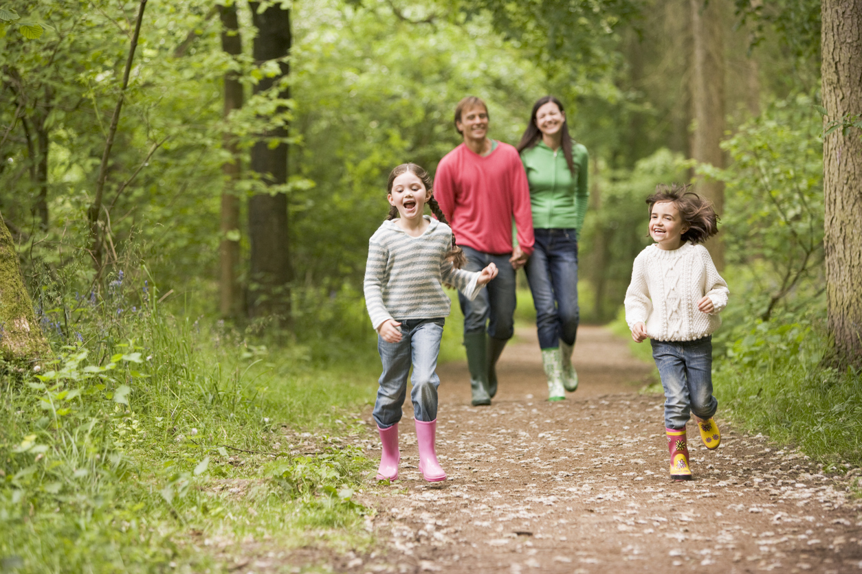 Family walking together through a wooded area