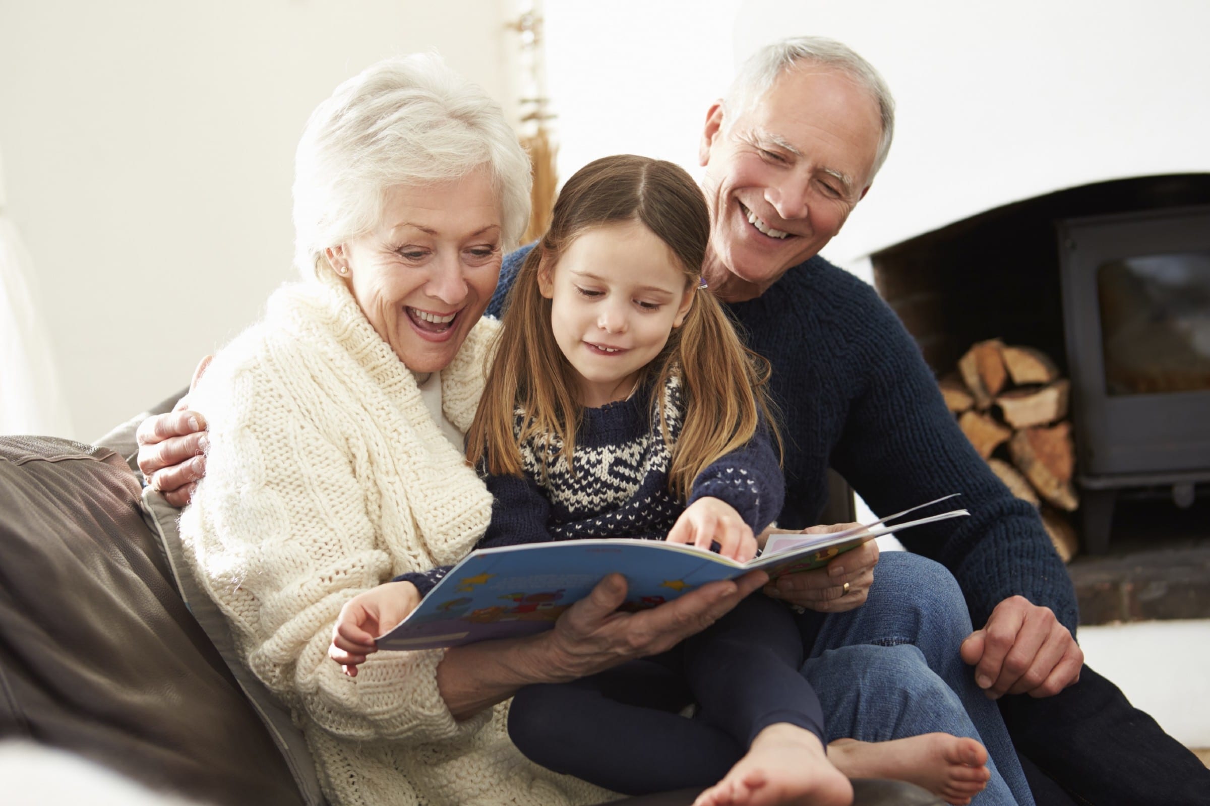 Grandparents reading with their granddaughter